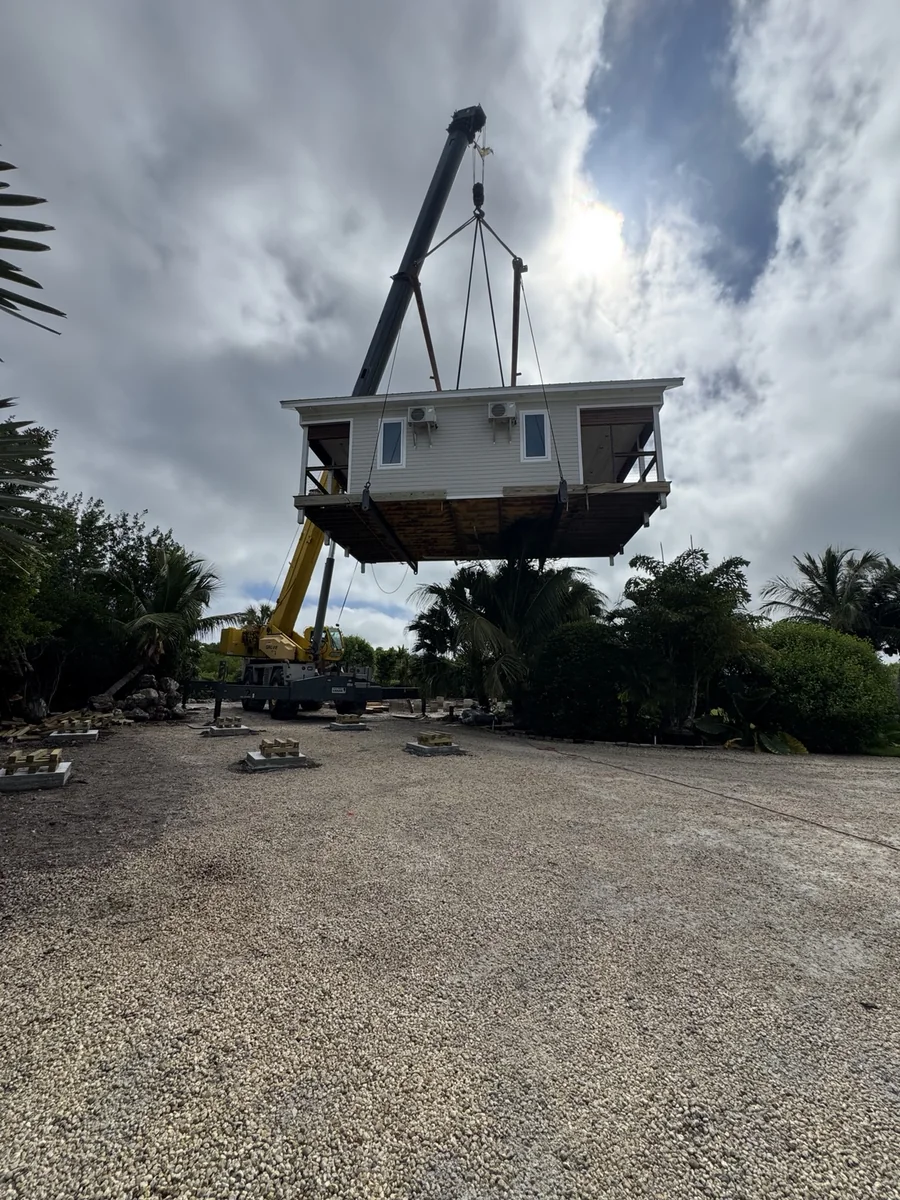 Crane lifting an existing residential structure during a house relocation project.