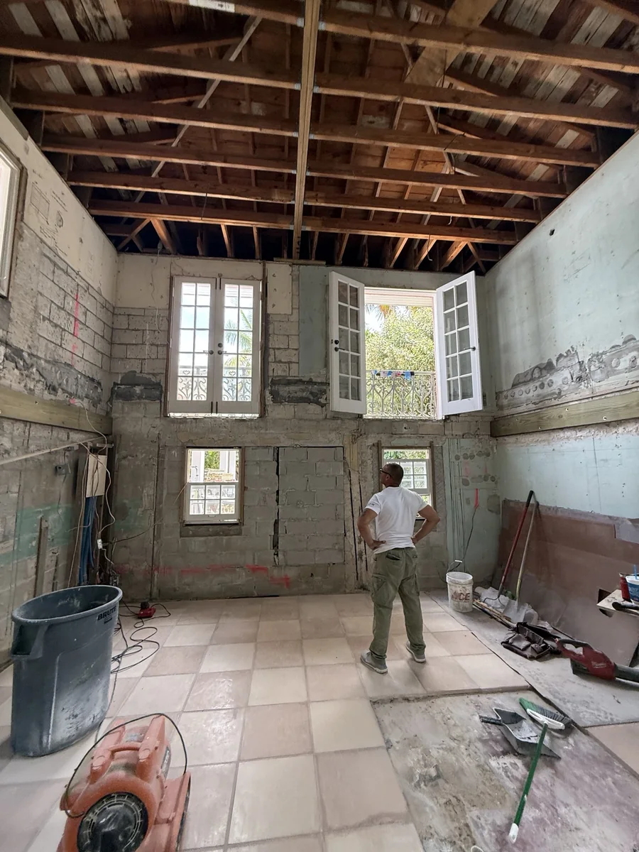 Tall room with exposed ceiling framing and masonry undergoing extensive renovation.