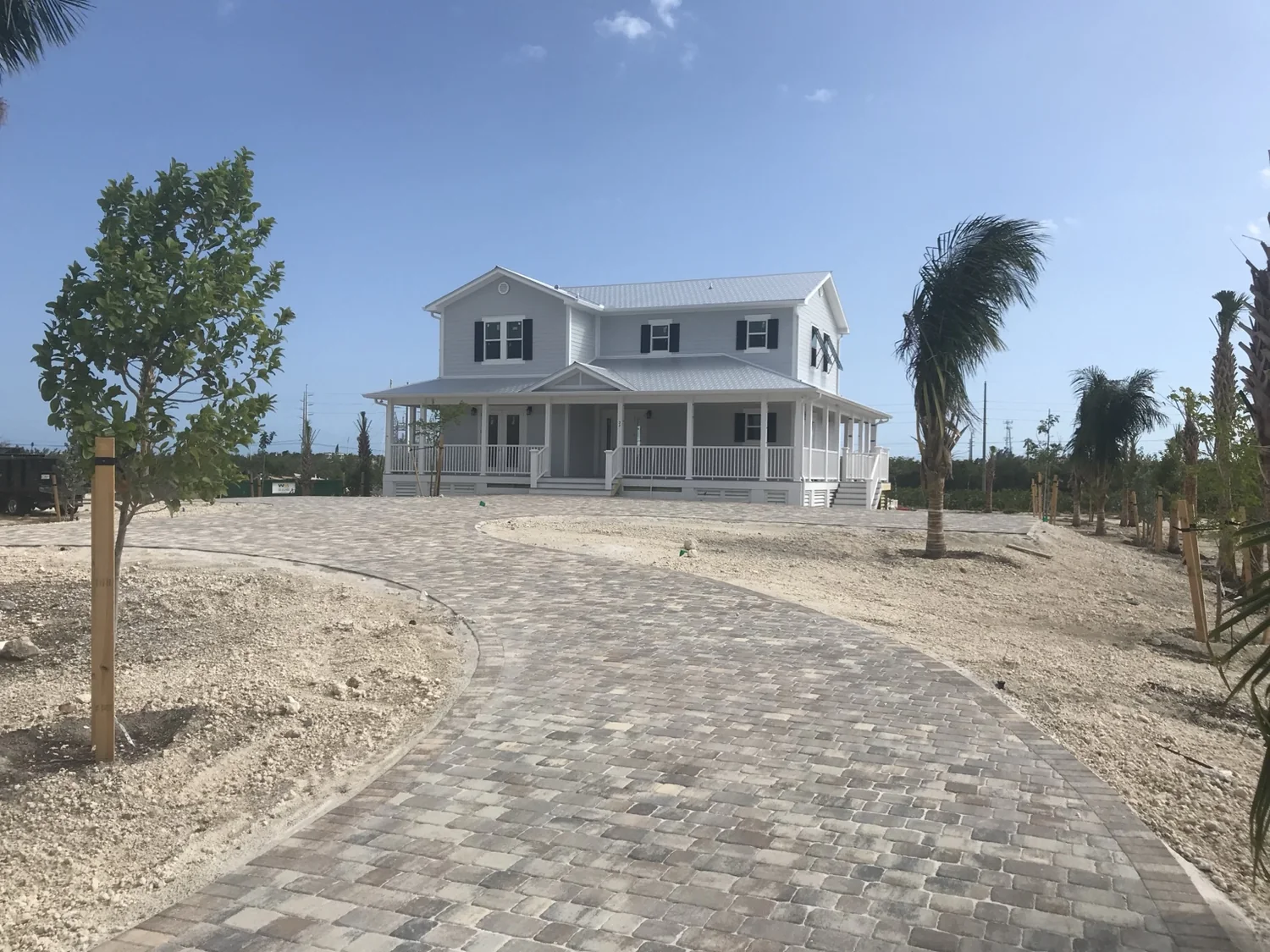 Completed coastal home viewed from the stone-paver driveway.